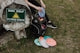 a person sitting on a tree stump with a backpack and a sign