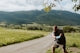 a man throwing a frisbee on a dirt road