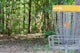 a frisbee golf cage in a wooded area