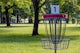a frisbee golf cage in a park with trees