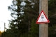 a red and white sign on a wooden pole