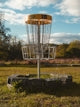 a frisbee golf basket in a grassy field