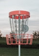 A frisbee golf basket with chains attached to it
