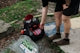 Person reaching for disc golf bag next to course map