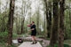 Man throwing a disc golf disc in a wooded park