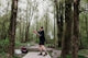 Man throwing a disc golf disc in a wooded park.